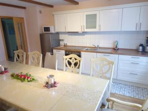 a kitchen with a table and chairs and a kitchen with white cabinets at Im Haus am Ries in Ehingen am Ries
