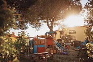 a park with a playground with a slide and a tree at Residence il Mandorlo in Lacona