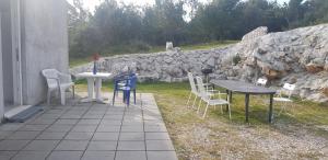 a patio with a table and chairs and a stone wall at Studio Apartment Sanja 4 in Neum +12 photos