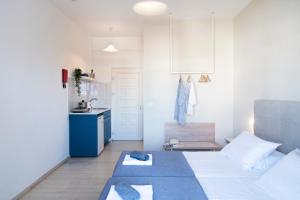 a bedroom with a white bed and white walls at Ammos Apartments in Kavos