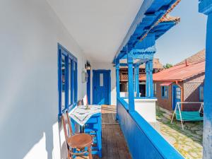 un balcon bleu avec une table et une chaise dans l'établissement Casa de vacanta traditionala romaneasca, à Schiuleşti
