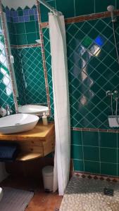 a green bathroom with a sink and a mirror at Casa Paraiso in Benajarafe
