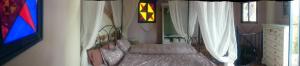una camera con un letto in una stanza con finestre di Casa Paraiso a Benajarafe