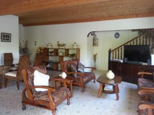 a living room with chairs and a flat screen tv at Zanboza Guesthouse in La Digue