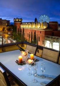un tavolo con candele e bicchieri da vino sul balcone di Apartamento ático enfrente del Museo Dalí a Figueres