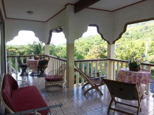 a porch with chairs and a table with a view at Zanboza Guesthouse in La Digue