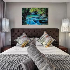 St Lucia Hilltop Guest House في سانت لوسيا: غرفة نوم بسرير مع لوحة على الحائط