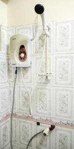 a shower in a bathroom with a white tiled wall at Shimbwe Meadows Home in Moshi