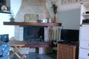 a living room with a fireplace and a television at Casa del pescatore Giannutri in Giannutri