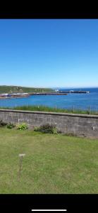 a field with a view of a body of water at Four waves in Thurso