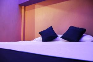 a bed with two blue pillows on top of it at Hotel Oasis in Monterrey