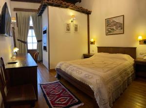 a bedroom with a bed and a table and a desk at Hotel Mangalemi in Berat