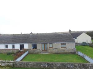 a house with a large yard in front of it at Four waves in Thurso