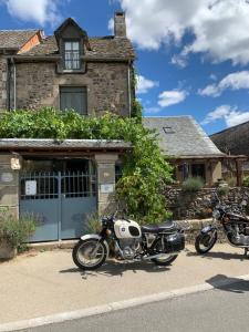 deux motos garées devant une maison dans l'établissement Au Pont d’Olt, à Saint-Côme-dʼOlt