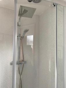 a shower with a glass door in a bathroom at Four waves in Thurso