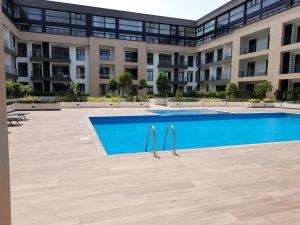 a swimming pool in front of a large building at Embassy Gardens Studio in Accra