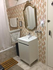 a bathroom with a sink and a mirror and a tub at Casa Vintage Guest House in Peniche +55 photos
