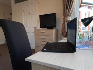 a laptop computer sitting on top of a desk at Revado Hotel in Norwich