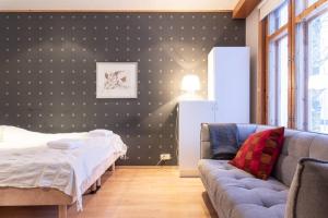 a living room with a couch and a bed at Cozy 1 Br Apt and Free parking by the Railway station in Oulu