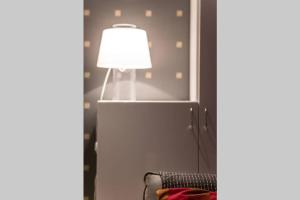 a lamp in a living room with a couch at Cozy 1 Br Apt and Free parking by the Railway station in Oulu +17 photos