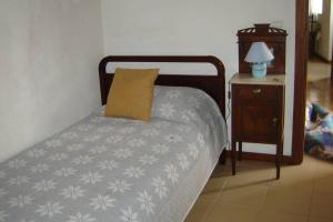 a bedroom with a bed with a pillow and a nightstand at Silveira's Home in Lajes do Pico