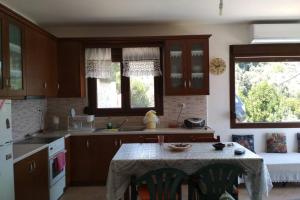 eine Küche mit einem Tisch in der Mitte in der Unterkunft Balcony to the Aegean Sea - Pelion, Lampinou in Pilion