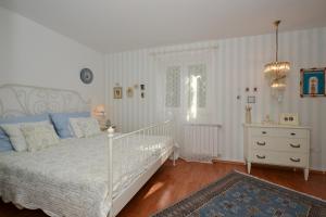 a bedroom with a white bed and a dresser at VIlla Three Palms in Murter