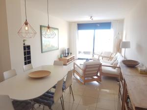 a living room with a white table and chairs at Beautiful apartment 75m2 with view at the beach, pool, parking in Roses