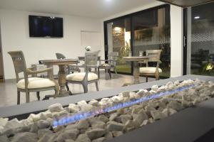 a fire place in a room with chairs and tables at Hotel San Francisco in Ubaté