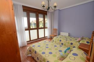 a bedroom with two twin beds and a window at Apartamentos Pineda in Noja