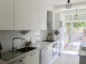 a kitchen with white cabinets and a sink at Silver Coast Beach House in Torres Vedras
