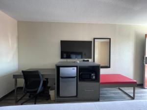 a room with a desk and a red bench and a tv at Dreamland Inn in Marion