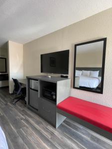 Habitación de hotel con cama y banco rojo en Dreamland Inn, en Marion