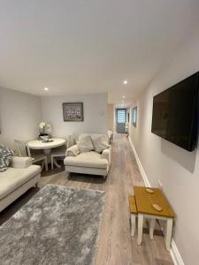 ein Wohnzimmer mit einem Sofa, einem TV und einem Tisch in der Unterkunft Dancy Mews Over 30's Only apartment in Tavistock