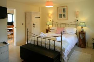 a bedroom with a bed and a desk and a television at The Park at Mawgan Porth in Saint Eval