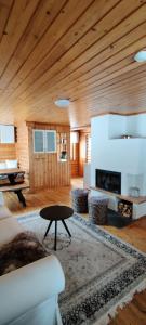 a living room with a wooden ceiling and a fireplace at Lohelanranta in Kemijärvi