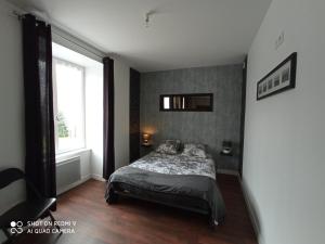 a bedroom with a bed and a large window at LE P'tit logement de lor'Phée in Chantepie