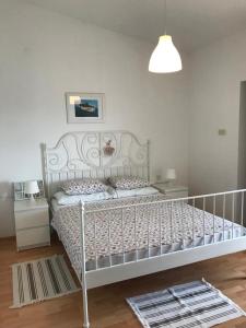 a white bed in a bedroom with a lamp at Apartmani Darko in Kornić