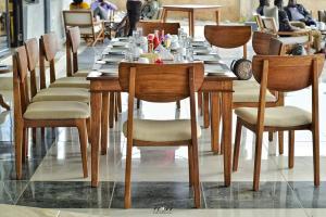 a long wooden table with chairs in a restaurant at The Willis Hotel, Bomet in Bomet