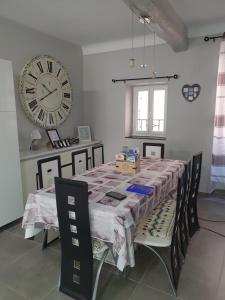 a dining room table with a large clock on the wall at Maison de village à carces in Carcès +16 photos