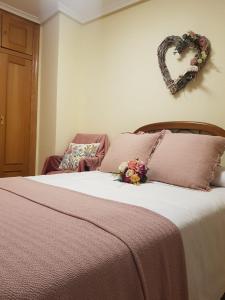 a bedroom with a bed with a heart sign on the wall at La Casa del Valle in Soncillo