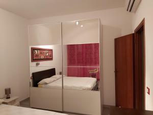 a bedroom with a glass cabinet with a bed in it at Le Logge Apartment in Baratti