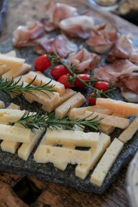 a tray of cheese and meats on a table at B&B Il Tabià in Pieve di Cadore