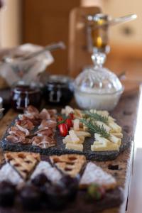 una mesa cubierta con diferentes tipos de queso y carne en B&B Il Tabià, en Pieve di Cadore
