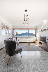 a living room with a chair and a large window at Foz Sunshine in Caminha