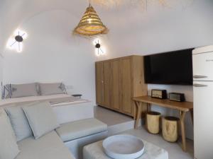 uma sala de estar com um sofá e uma televisão em Imarkellis Santorini em Pirgos