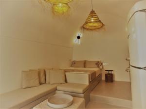 uma sala de estar com um sofá e um banco em Imarkellis Santorini em Pirgos