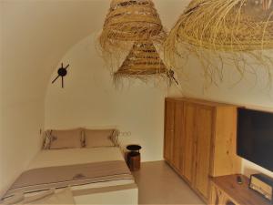 a bedroom with a bed and a flat screen tv at Imarkellis Santorini in Pirgos