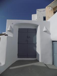 a white building with a garage with two doors at Imarkellis Santorini in Pirgos