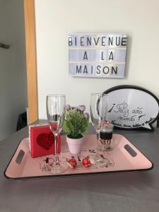 a tray with two wine glasses and a box of roses at La casita de Vanessa in Changé